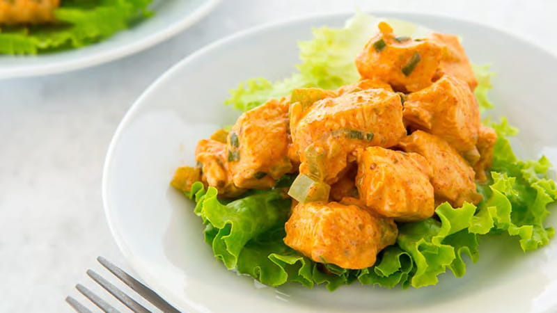 a plate of cubed chicken on a bed of lettuce