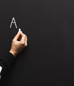 Woman writing the letter A on a chalkboard Woman writing the letter A on a chalkboard