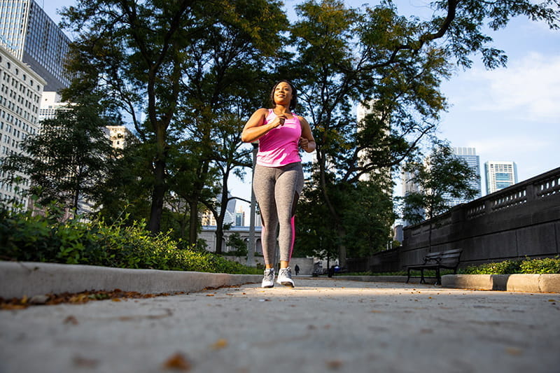 mujer caminando en una acera en el centro de la ciudad