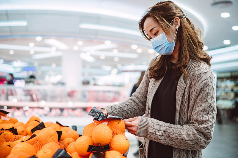 mujer comprando con una mascarilla