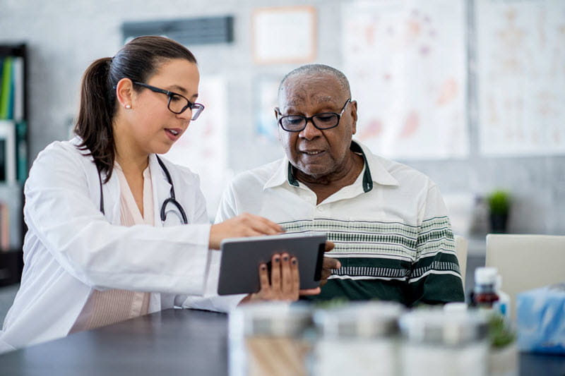 man looking at table with doctor