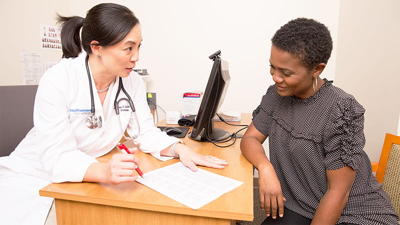 Doctor reviewing lab work with patient at her desk