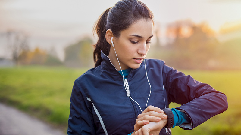 Woman outdoors working out looking at watch