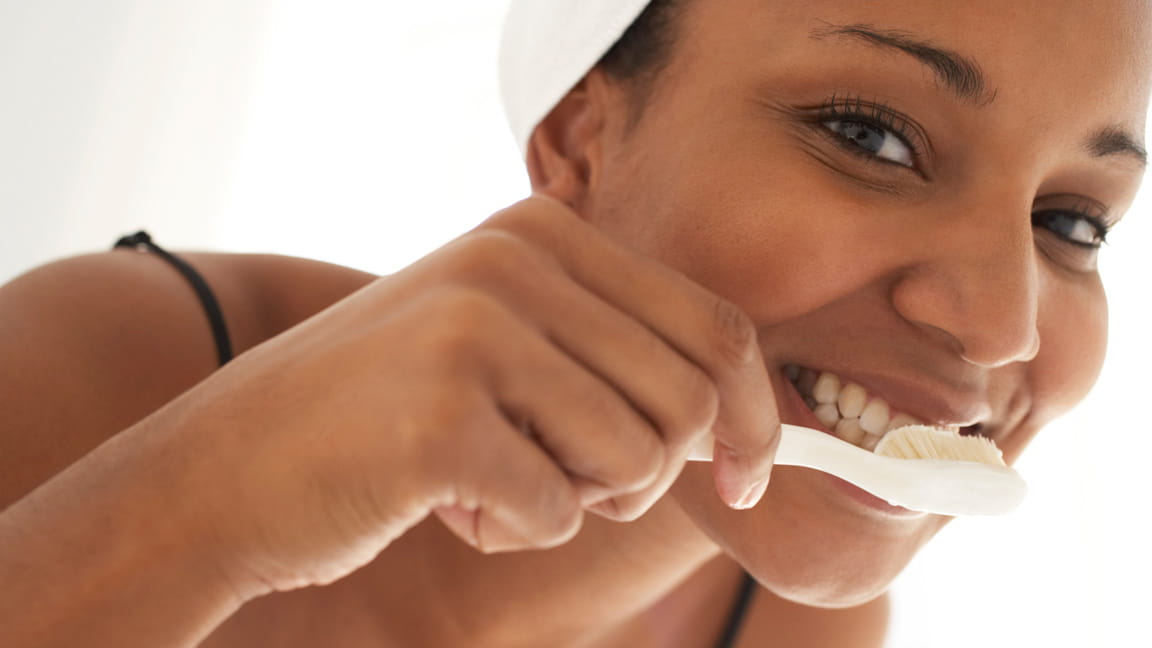 young woman brushes her teeth