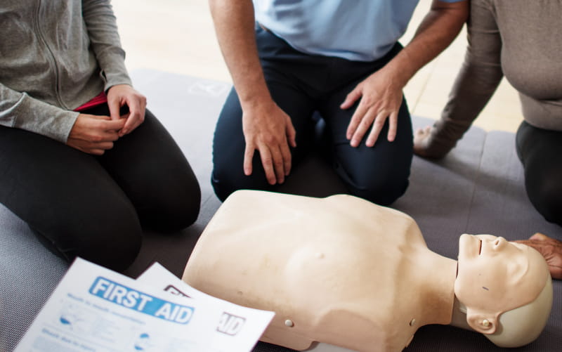 People around CPR manikin.