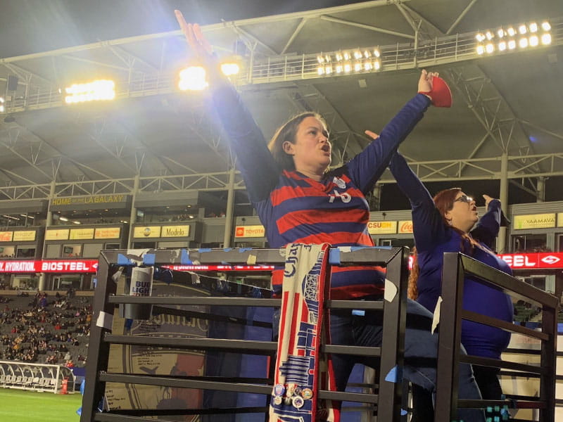 Crystal Cuadra-Cutler (izquierda) dirige a los fanáticos en las gradas en un canto durante un partido de fútbol en Carson, California, en 2021. (Foto cortesía de Rob Hendricks)