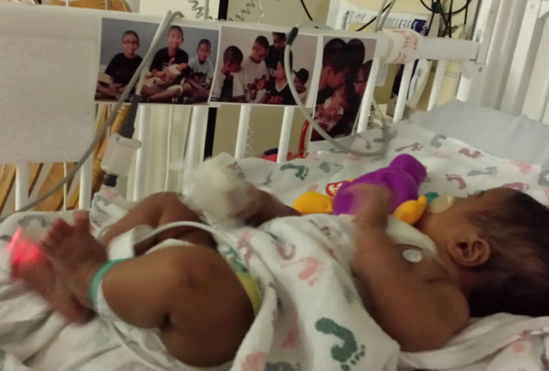 Luke Domingo was in the hospital for over a week to recover from his first heart surgery as an infant. His parents taped family photos in his crib to comfort him. (Photo courtesy of Mia Domingo)