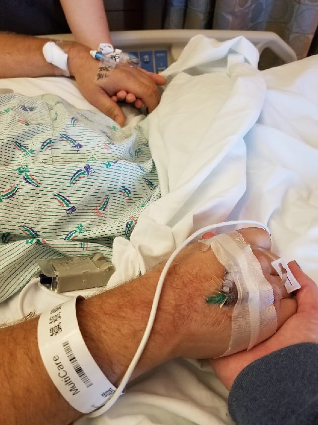 Will Treinen's daughters holding his hands shortly before open heart surgery. Photo courtesy of Treinen family.