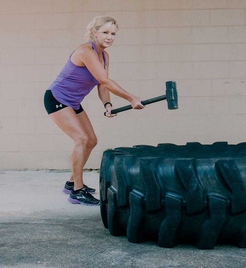 Angie Mayo whacking a tractor tire with a sledgehammer. (Photo courtesy of Josie Porter Photography)