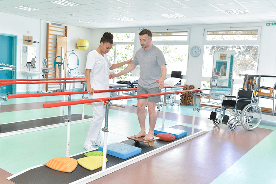 Hombre en equilibrio con fisioterapeuta