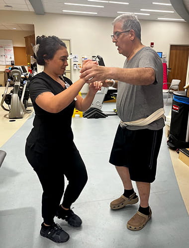 Stroke survivor, Manuel Vera, working with a physical therapist in rehab