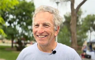 Steve Zuckerman smiling in a park setting