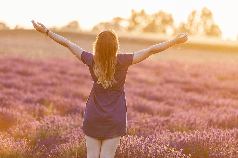 mujer feliz relajándose en un campo