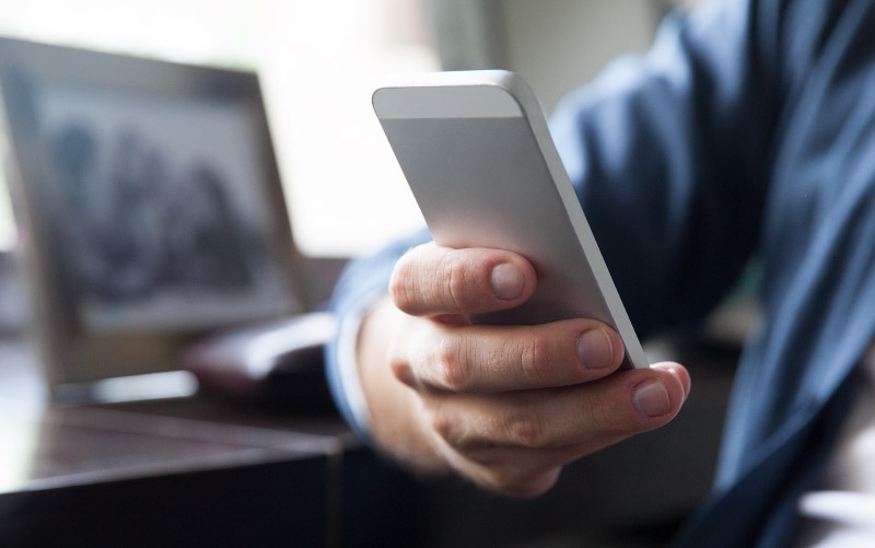 Man's arm holding mobile phone.