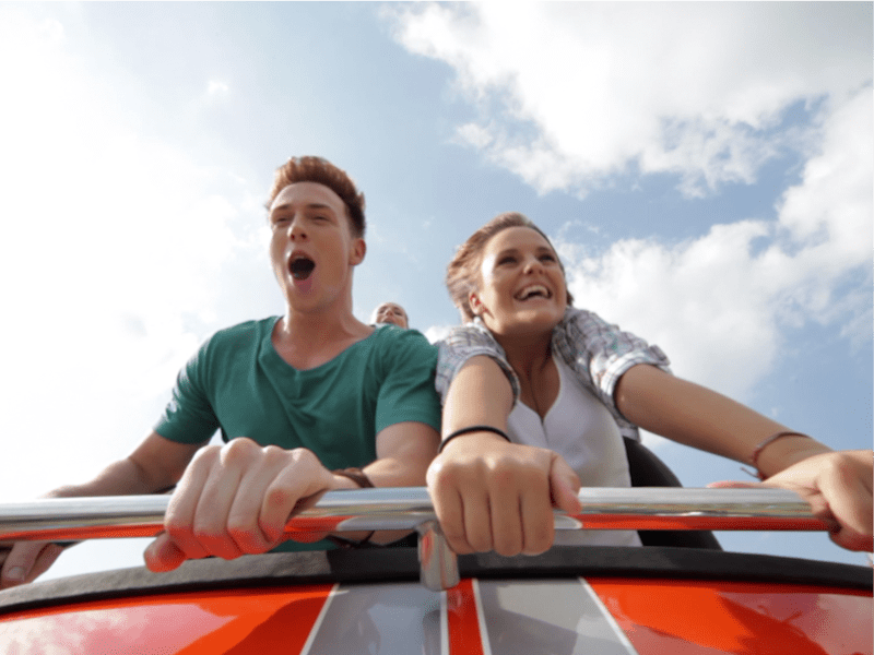 People riding roller coaster.