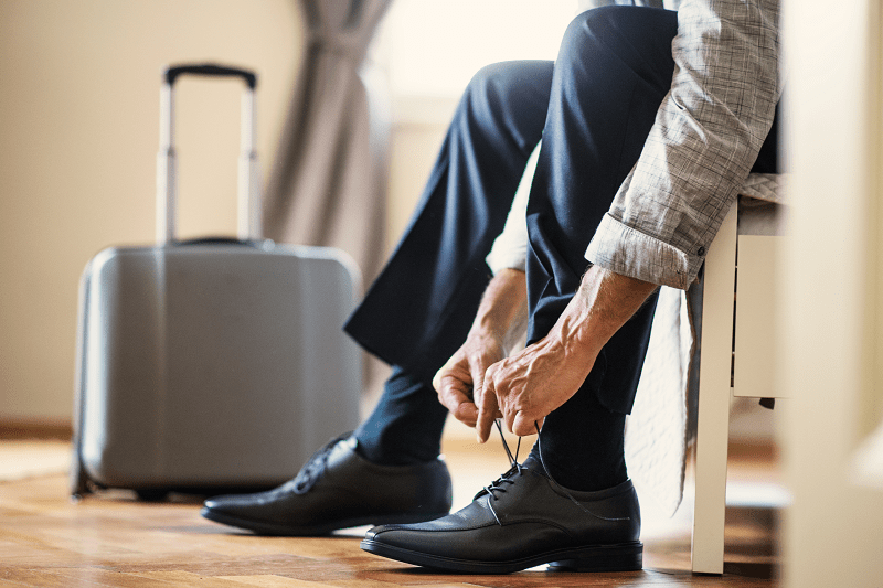 hombre sentado atándose los cordones de los zapatos